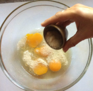 cracking eggs into a mixing bowl and then add the other wet ingredients to them.