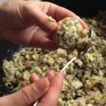 Placing the stuffing into the button mushrooms with a spoon