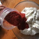 pouring the smoked strawberries into the mixture