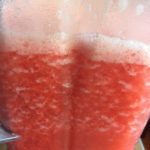 strawberries and simple syrup mixture in the blender adding ice to chill