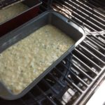 two batter pans on the grill for baking