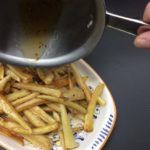 pouring the honey sauce over the finished grilled pasnips and ready to serve
